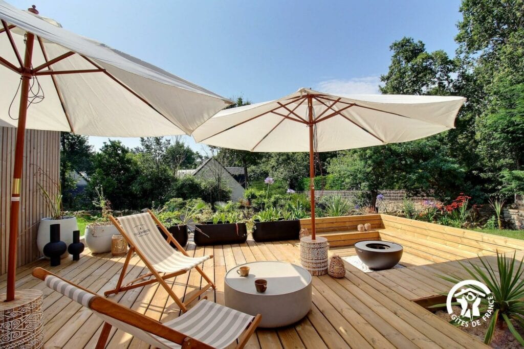 Espace extérieur de la Villa Namaste avec parasols, fauteuils et décoration naturelle.